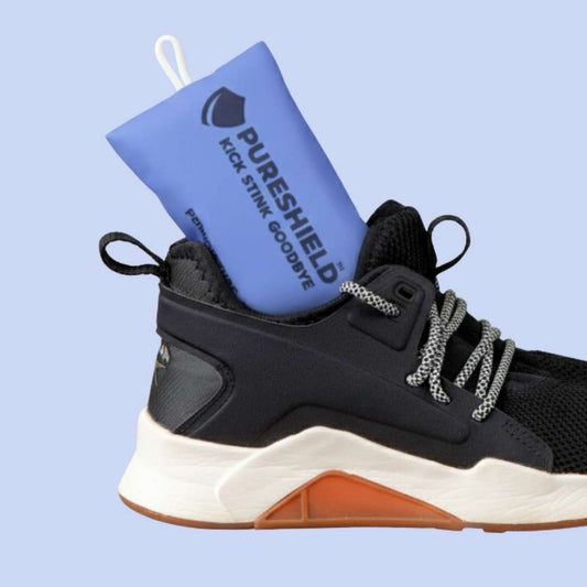 Black and white sneaker with a blue Pureshield shoe deodorizer on a light blue background